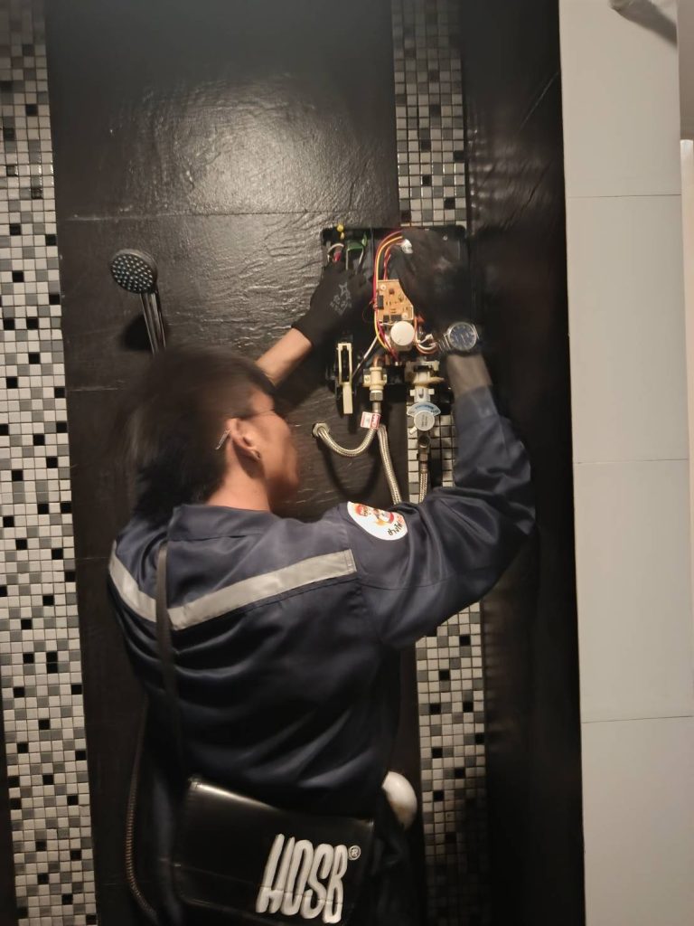 ช่างไฟฟ้ากำลังตรวจเช็กเครื่องทำน้ำอุ่น